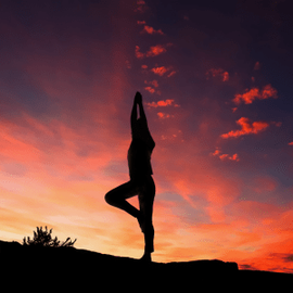 Yoga tree pose at sunset
