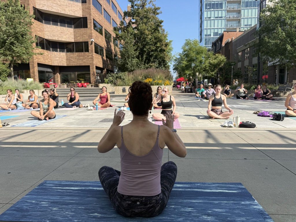 Marcie Evans leads a free outdoor yoga class at the Iowa City Downtown Wellness Festival
