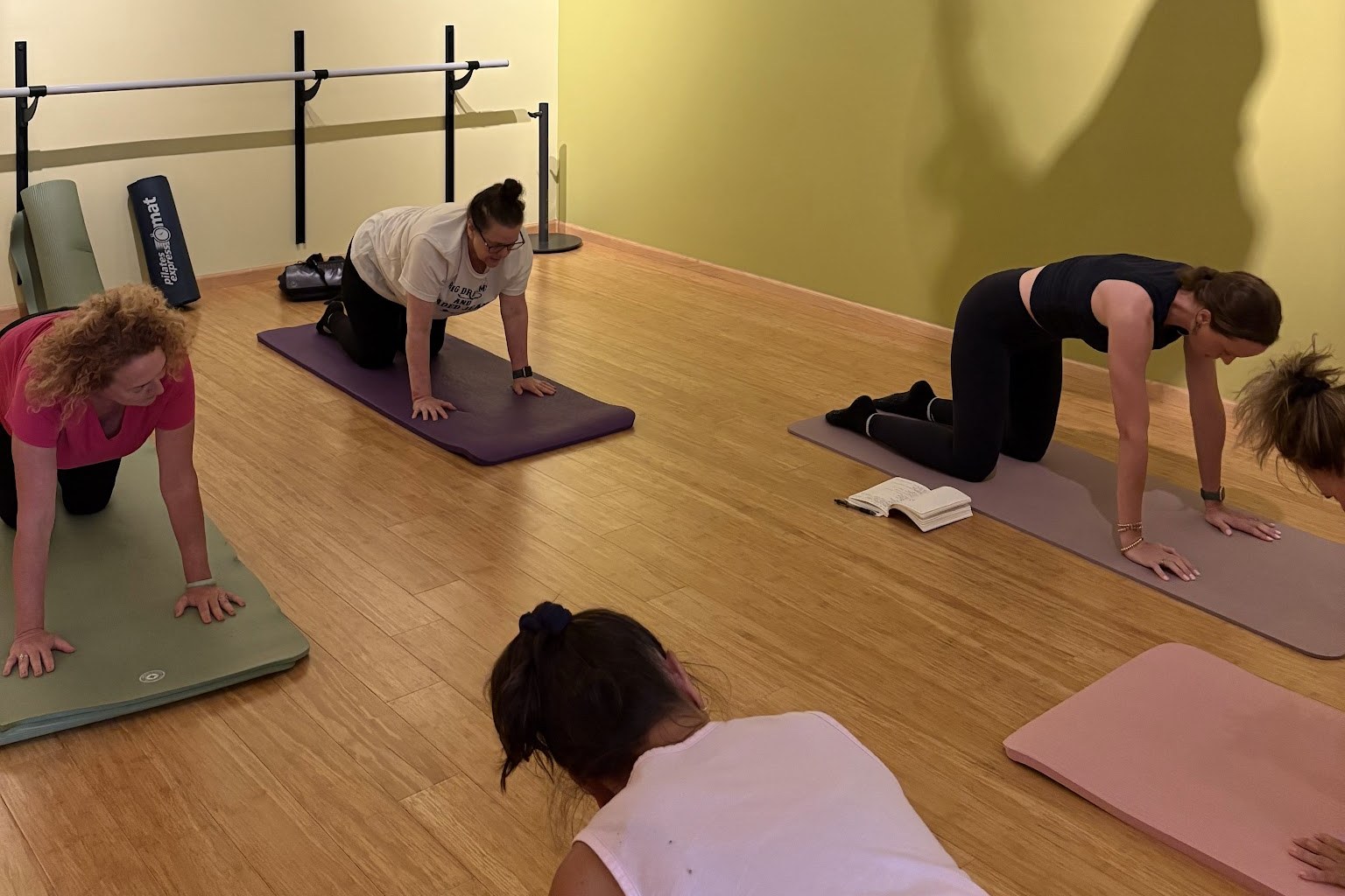 Students practicing tabletop position on their mats during the Intro to Pilates: Mat series at Serenity Yoga & Pilates Studio